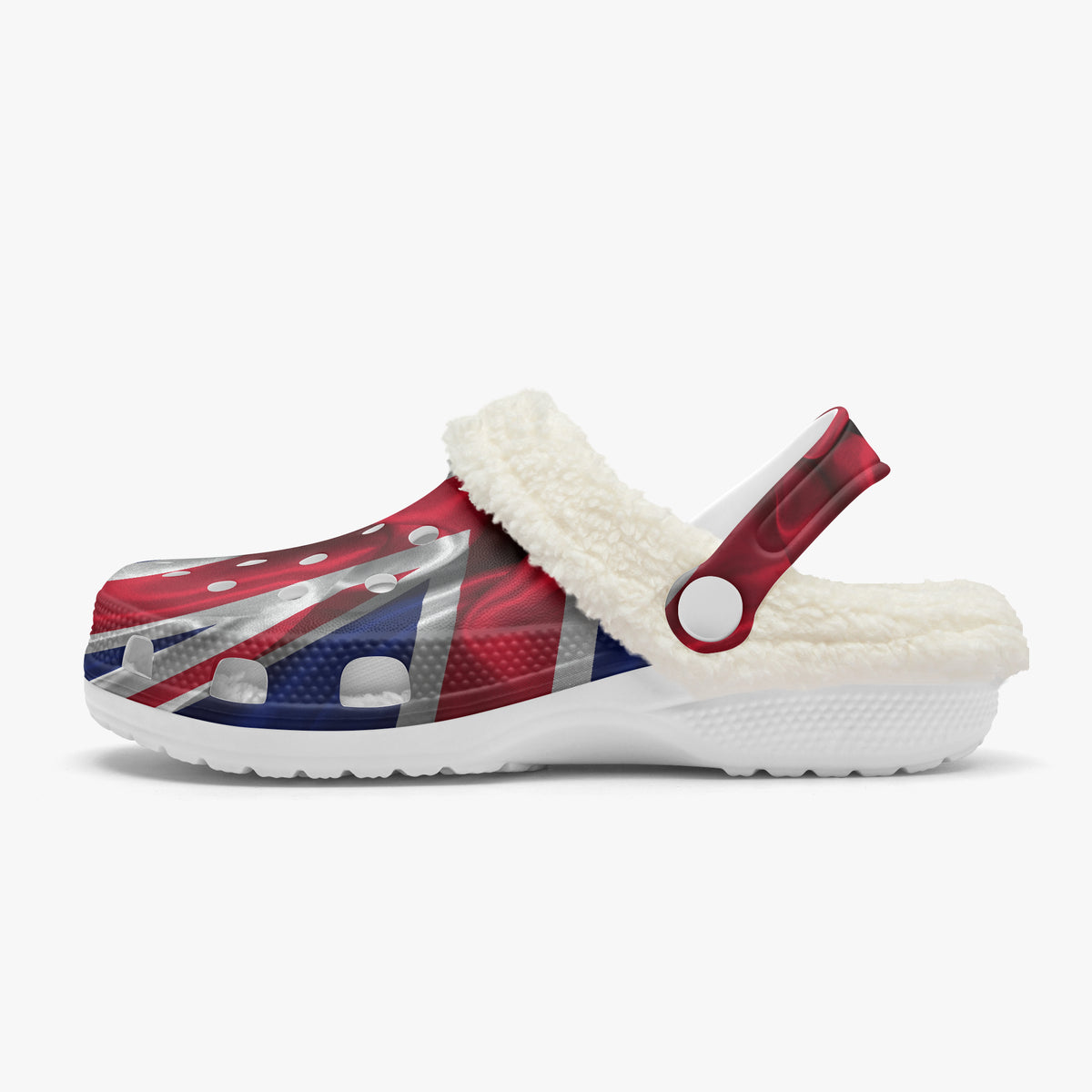 A single Croc-style clog shoe with a white sherpa lining and a strap, featuring a red, white, and blue Union Jack flag pattern on the upper, shown against a light gray background.