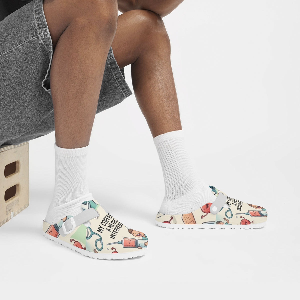 Nurse clogs on feet with white crew socks and medical coffee pattern
