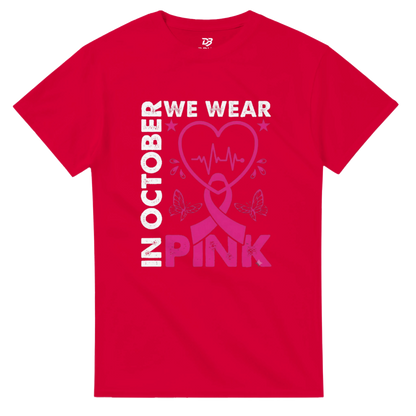 Red unisex T-shirt with 'OCTOBER WE WEAR PINK' heart ribbon graphic