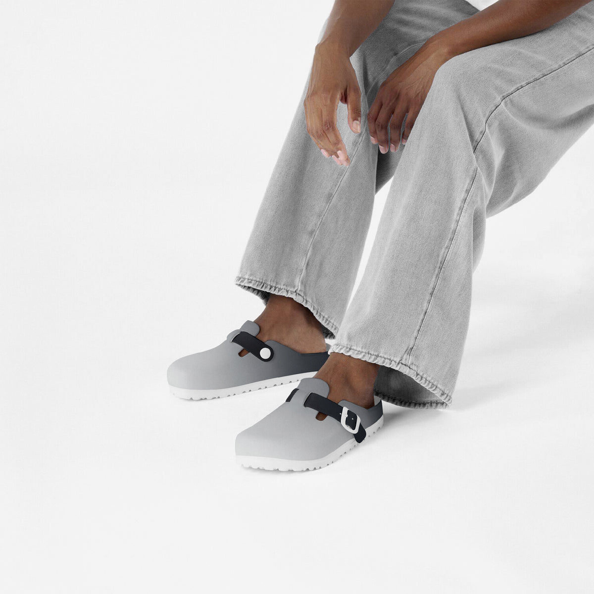Grey slip-on EVA clogs with black strap buckles and textured outsole