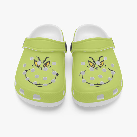 Pair of lime green kids clogs with cartoon face graphics and adjustable heel strap.