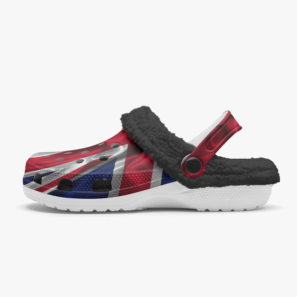 A single clog-style shoe with a Union Jack flag print on the upper, a black sherpa fleece lining, and a white sole, shown against a plain light gray background.