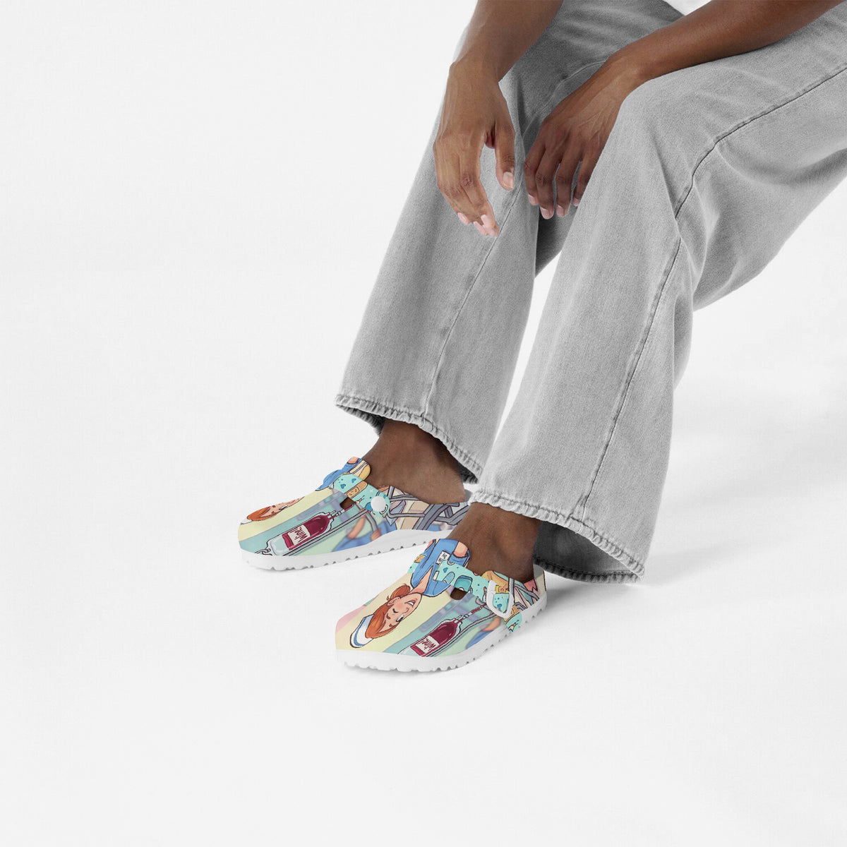 Nurse clogs worn by a person stepping forward, showing colorful cartoon nursing print.