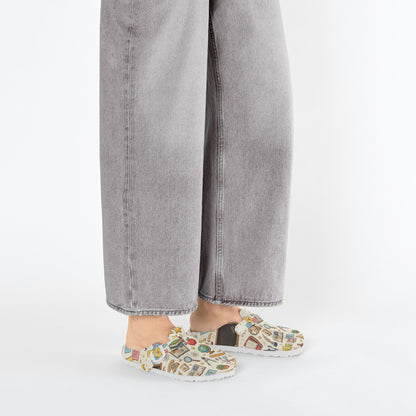 Close side view of slip-on clogs with white upper and colorful classroom icons
