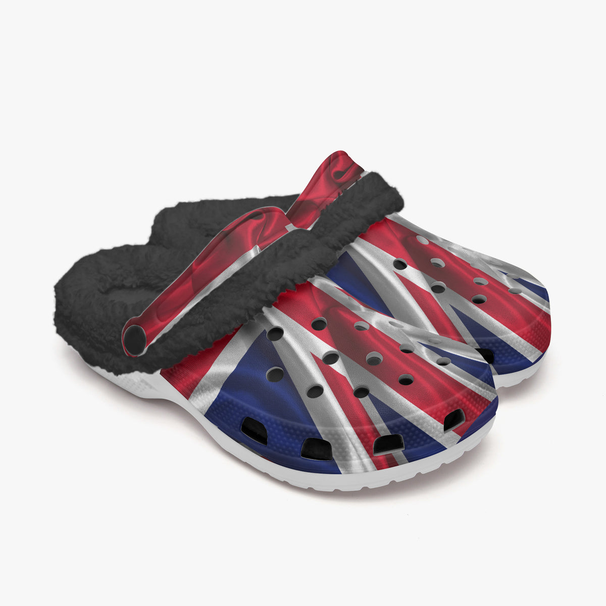 A pair of clog-style shoes with a Union Jack flag print on the upper and a black faux-fur lining, shown on a light gray background.