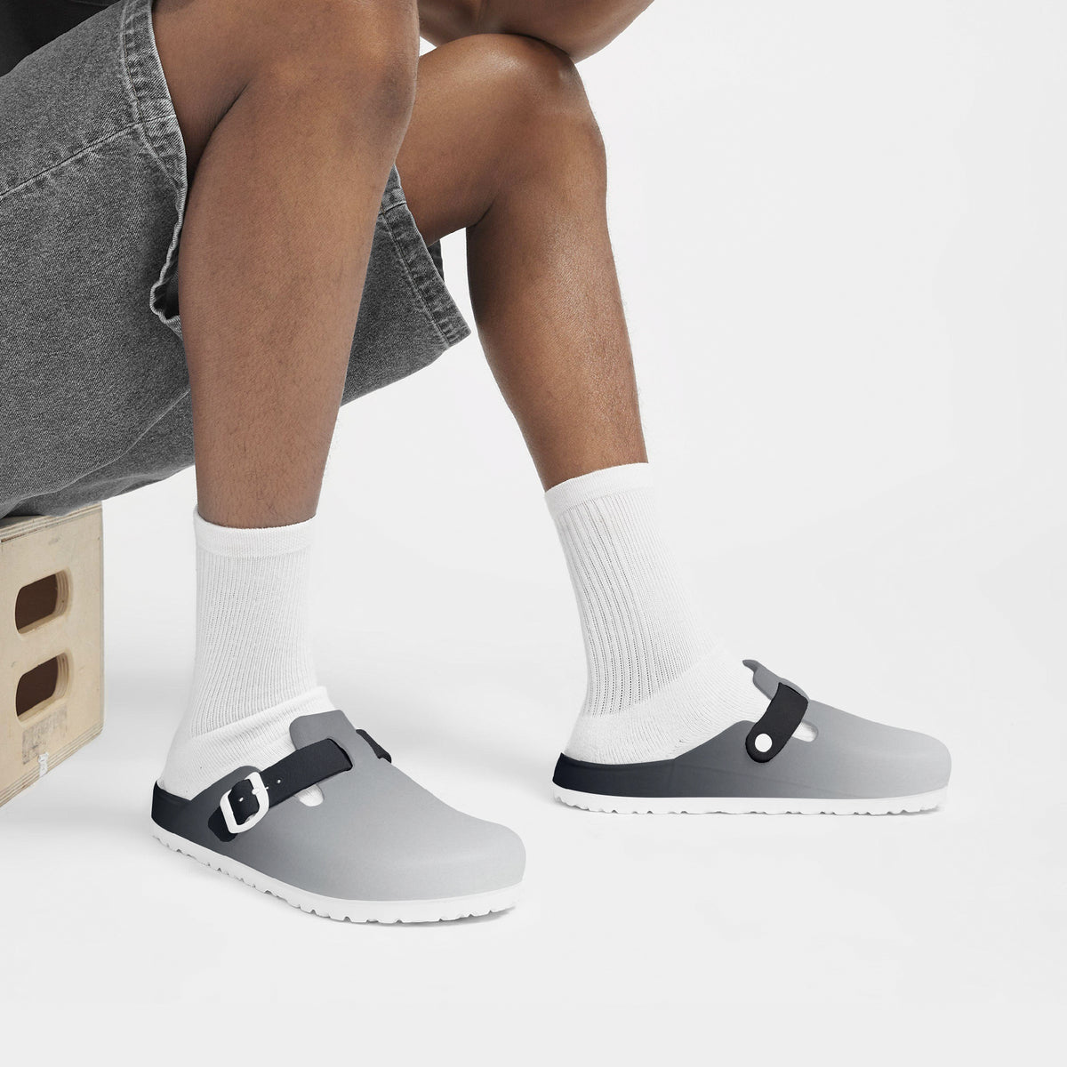 Grey EVA clogs worn with white socks, black strap buckle, grippy tread sole