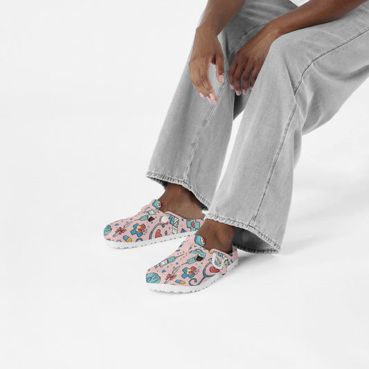 Person wearing pink medical doodle clogs with colorful cartoon print and white sole