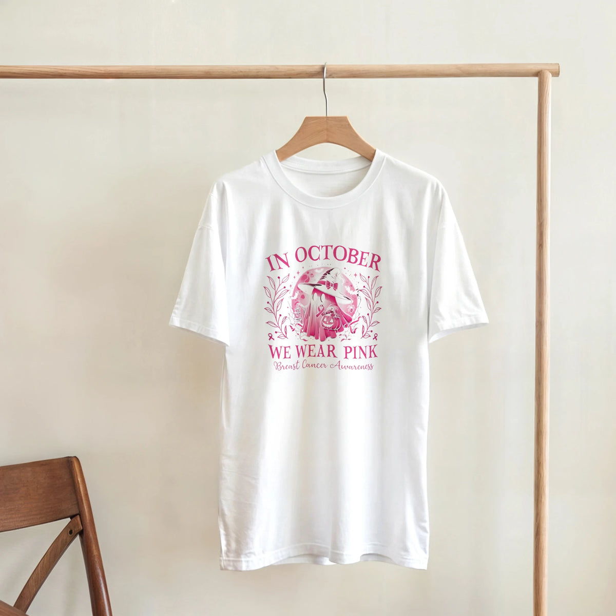 White crewneck unisex T-shirt on a hanger with pink awareness floral wreath graphic