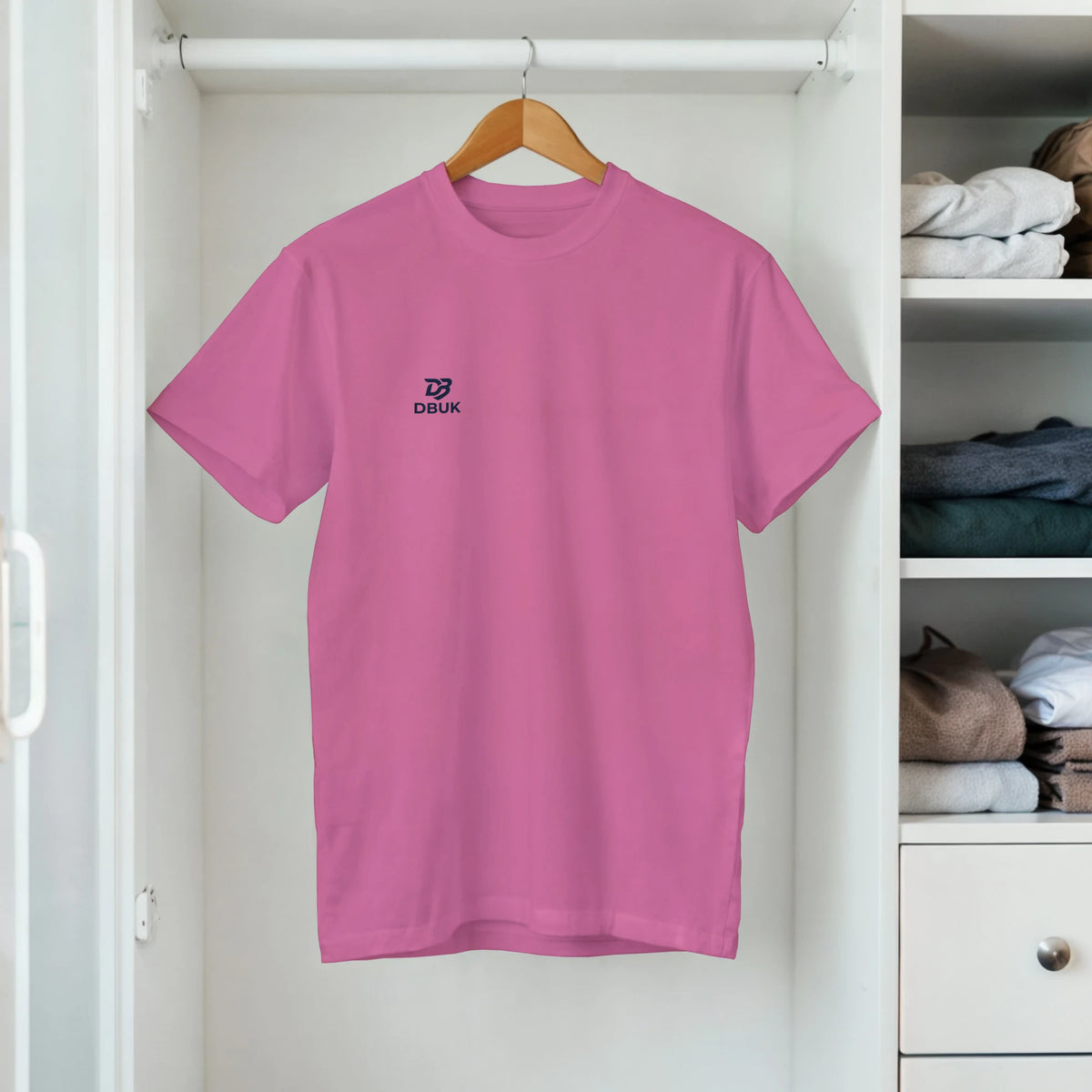 Women's crewneck T-shirt on hanger, pink with DBUK logo on chest