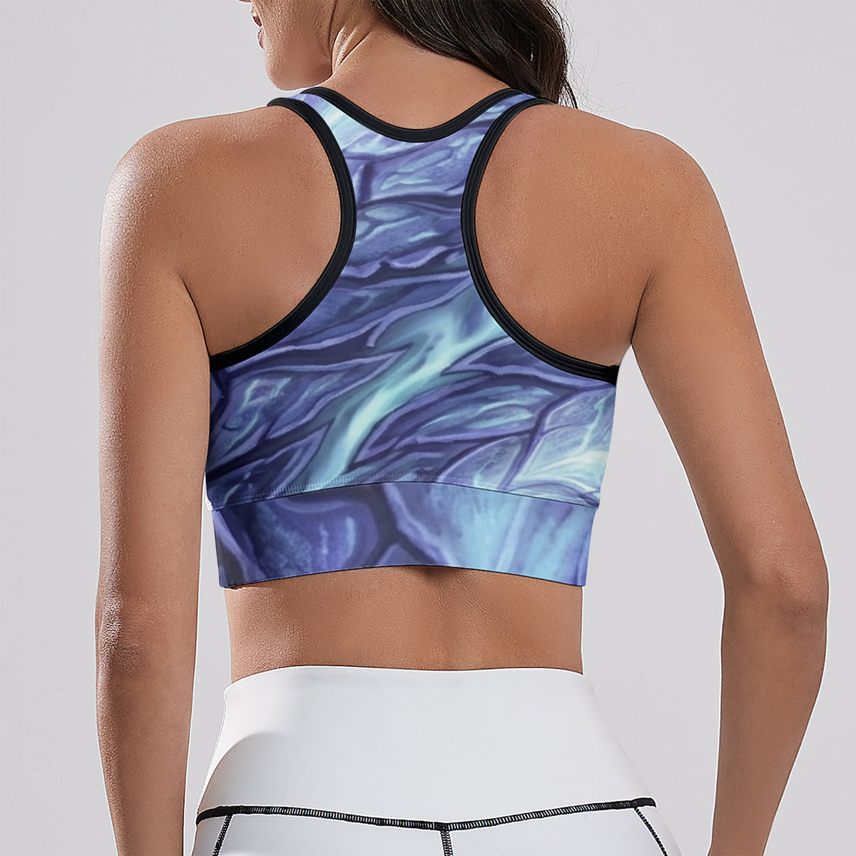 Back view of cropped racerback yoga tank with blue abstract all-over print and black contrast trim