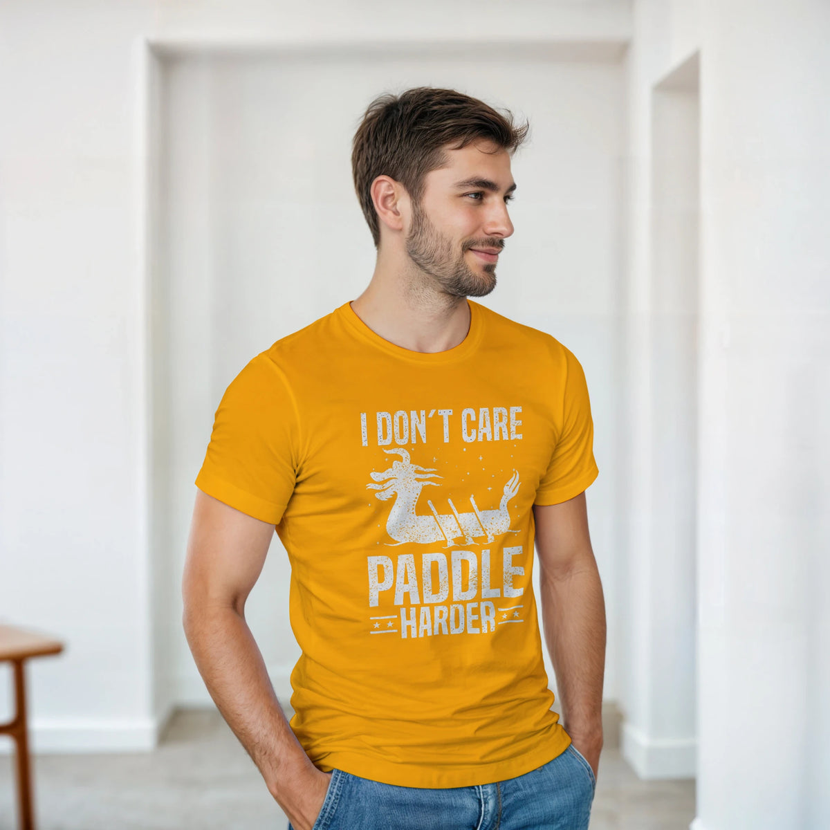 Model wearing a gold unisex crewneck T-shirt with white "I DON'T CARE PADDLIE HARDER" print